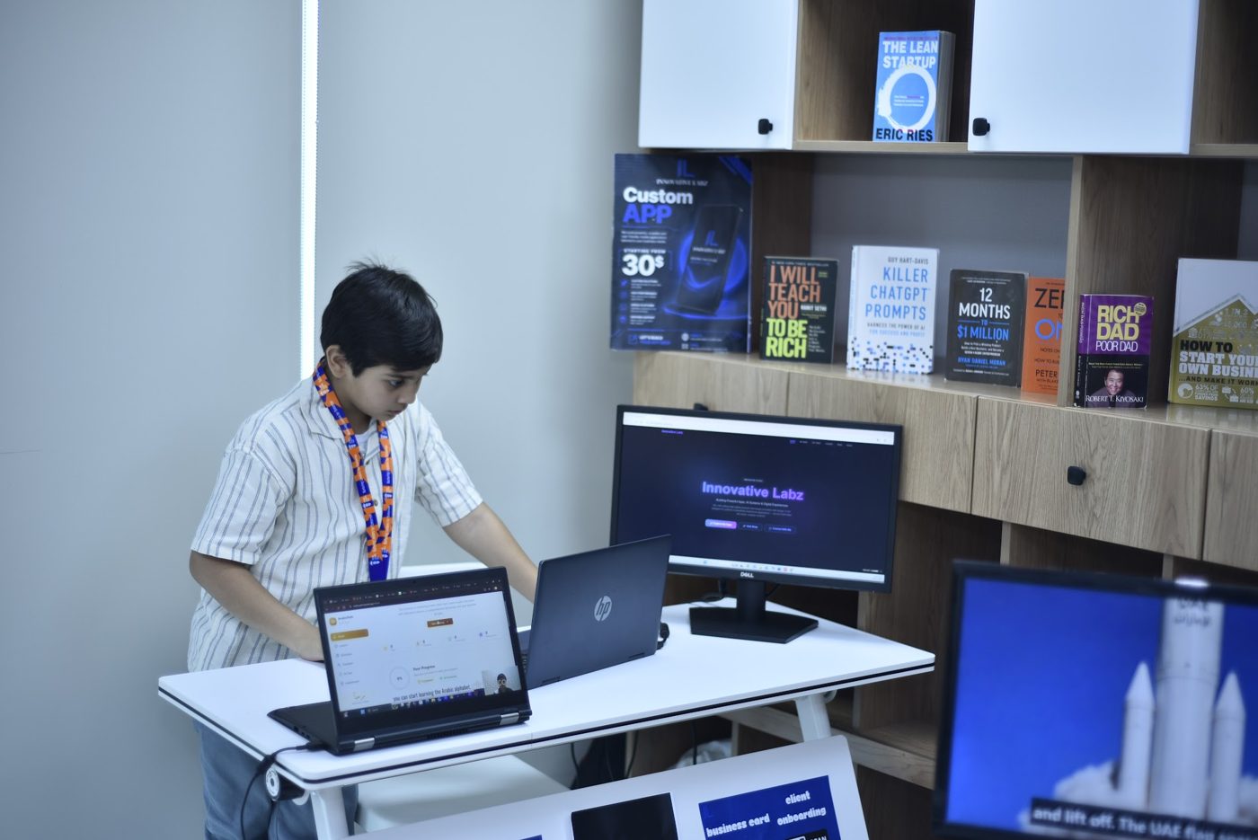 Young entrepreneur working on his Innovative Labz startup beside business books